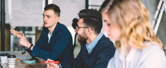 Équipe échangeant avec le chef de projet lors d’une phase de questionnement et d’analyse des besoins