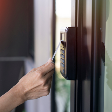 Collaborateur badgeant sur un système de pointage à l’entrée de l’entreprise avec un café à la main.