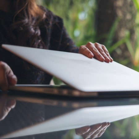 Utilisatrice fermant son ordinateur portable, illustrant l’autonomie et la simplicité offertes par un logiciel de gestion des congés et absences.