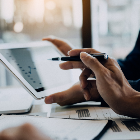 Deux collaborateurs analysent sur une tablette les graphiques d’un logiciel Reporting RH, en comparant des données RH et des indicateurs utiles au bilan social RH.